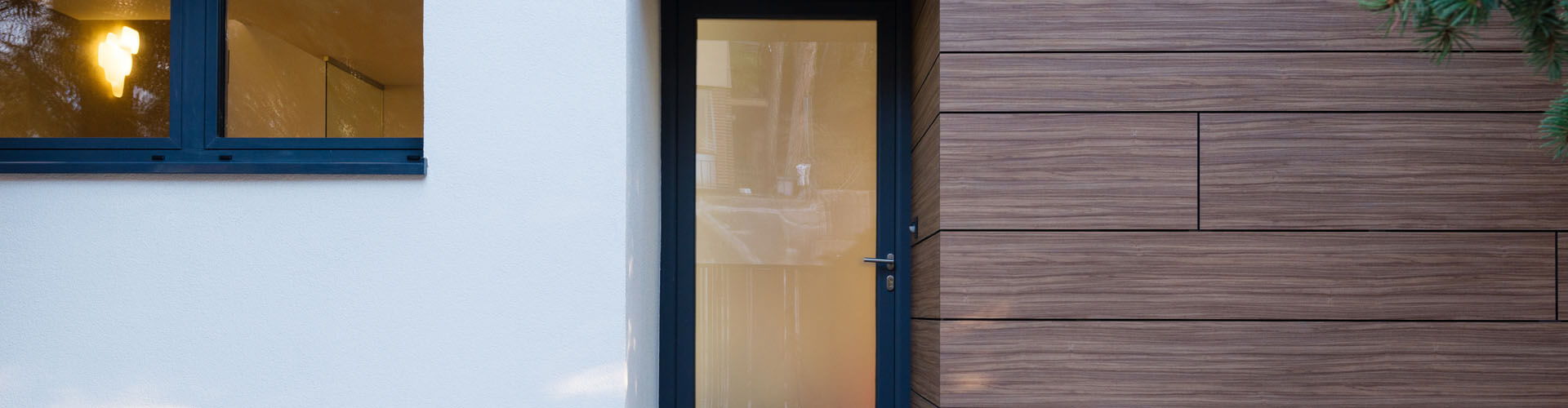 Porte d'entrée vitrée, fenêtres PVC et façade en bois